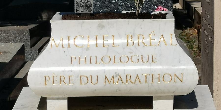 Jardinera de mármol grabada «Michel Bréal, philologue, père du marathon», letras doradas con pan de oro